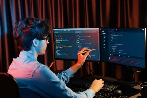 Working IT developer concentrating online software at neon light room. Gusher. 스톡 사진