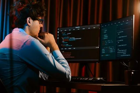 Working IT developer concentrating online software at neon light room. Gusher. Stockfoto's