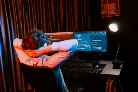 Working IT developer concentrating online software at neon light room. Gusher. Foto stock