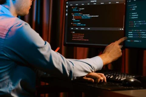 Working IT developer concentrating online software at neon light room. Gusher. Stockfoto's