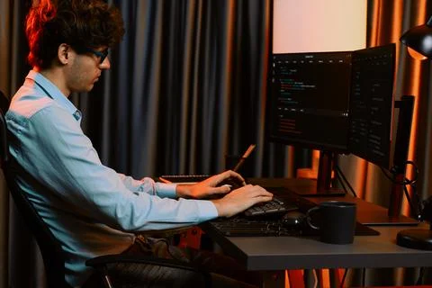 Working IT developer concentrating online software at neon light room. Gusher. 스톡 사진