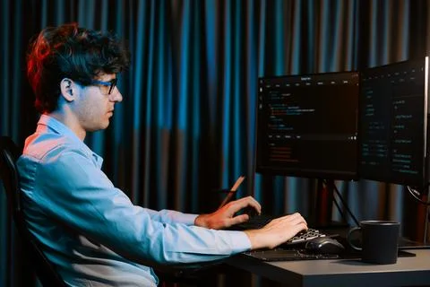 Working IT developer concentrating online software at neon light room. Gusher. Stockfoto's