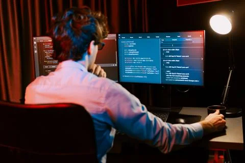 Working IT developer concentrating online software at neon light room. Gusher. 库存照片