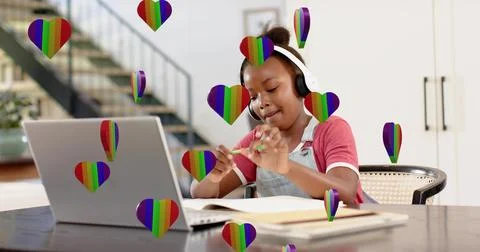 Working kid in white headset and denim overalls at home using laptop notebook Stock Photos