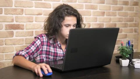 Working on a laptop computer, typing on a keyboard, modern teenager. A teenage 写真素材