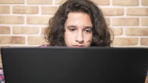 Working on a laptop computer, typing on a keyboard, modern teenager. A teenage 库存照片