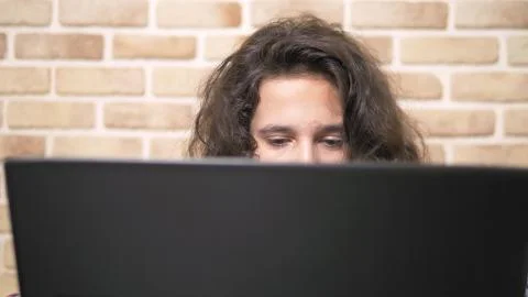 Working on a laptop computer, typing on a keyboard, modern teenager. A teenage 写真素材
