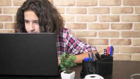Working on a laptop computer, typing on a keyboard, modern teenager. A teenage 库存照片