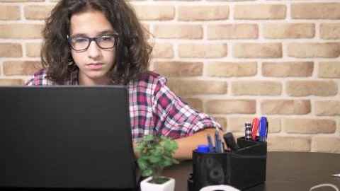 Working on a laptop computer, typing on a keyboard, modern teenager. A teenage 库存照片