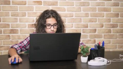 Working on a laptop computer, typing on a keyboard, modern teenager. A teenage 库存照片