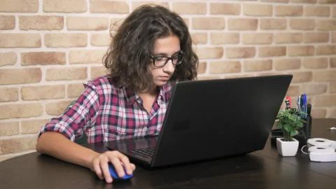 Working on a laptop computer, typing on a keyboard, modern teenager. A teenage 库存照片