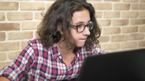 Working on a laptop computer, typing on a keyboard, modern teenager. A teenage 写真素材