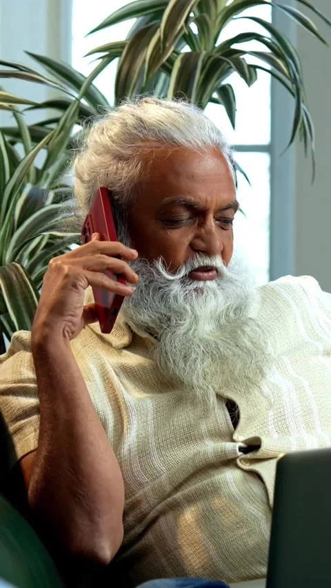 Working on laptop during phone call, mid age Indian man reviewing reports Stock-Footage 342757123