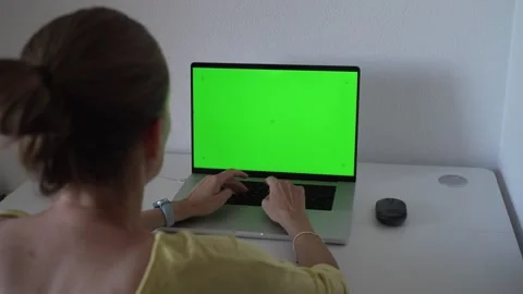 Working on a laptop with a green screen, typing and preparing for a project.. Stock Footage 340189806