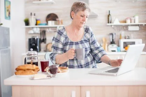 Working on laptop in kitchen Fotos Stock