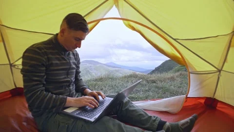 Working with a laptop in the mountains in a tent Stock Footage 221563469