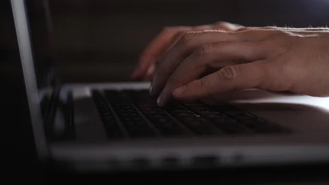 Working at laptop pc at night. Close up of male hands typing text or programming Stock Footage 103221804