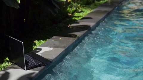 Working on laptop from the swimming pool Stock Footage 72677185