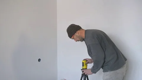 Working with a laser level makes markings on the wall Stock Footage 74764139