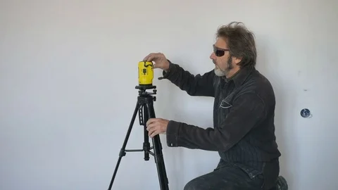 Working with a laser level makes markings on the wall. Mechanical lifting Video stock 74764257