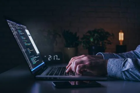 Working late at night on a laptop with a clock showing the time Stock Photos