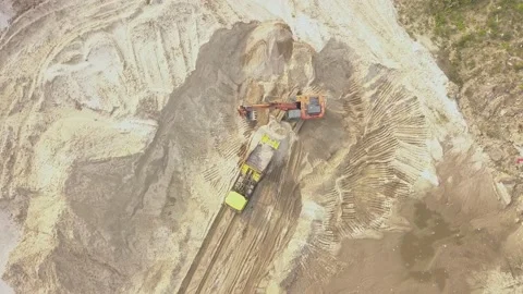 Working machines pour sand into a loading excavator in a quarry, there is a lot Stock Footage 166052416