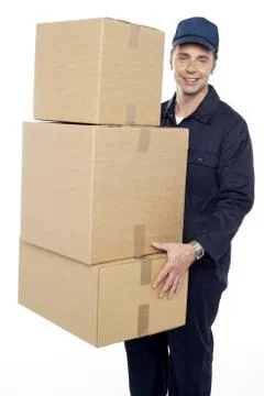 Working man delivering stack of cardboard boxes Stockfoto's