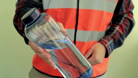 Working man give to the camera plastic bottle with drinking water. Stock Footage 107426204