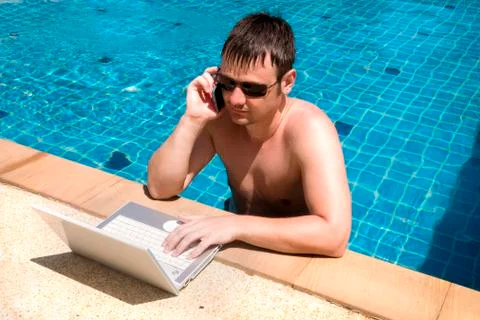 Working man with laptop in pool Stock Photos