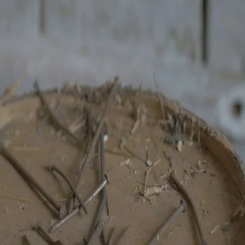 Working man pours rusty nails on the table in a workshop at the farm wooden Stock-Footage 69667519