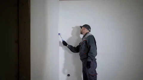 Working man is priming wall in flat. Stock Footage 84094509