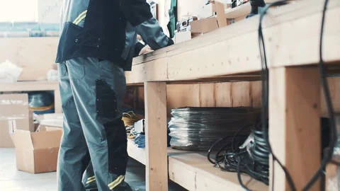 Working man in a special robe behind a wooden rack Stock Footage 88331277