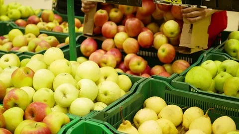 A working man in the supermarket puts the fruit apples in the trays Stock Footage