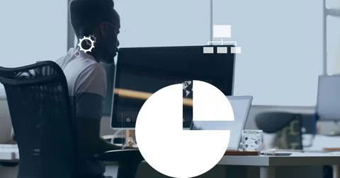 Working man typing code at office desk, with dual screens and patterned mug, 写真素材