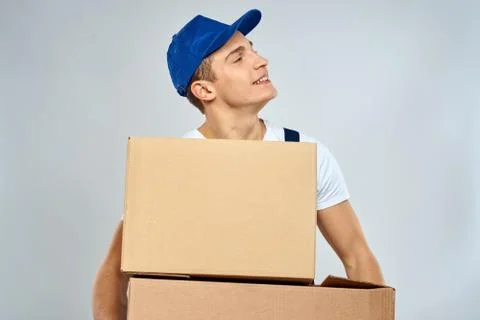 Working man in uniform with boxes in his hands delivery loader lifestyle Stock Photos