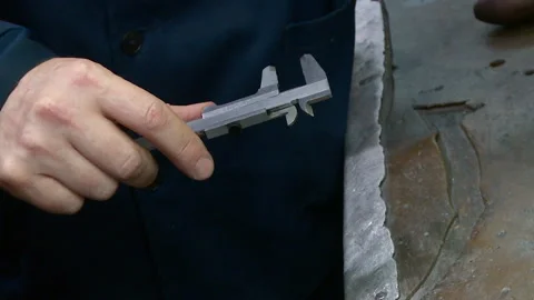 Working measures the size of the workpiece with a caliper Stock Footage 96826675