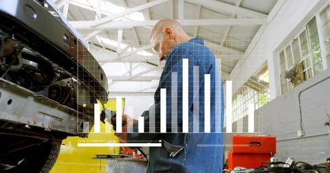 Working mechanic in blue coveralls using tool on open engine bay at workshop Stock Photos