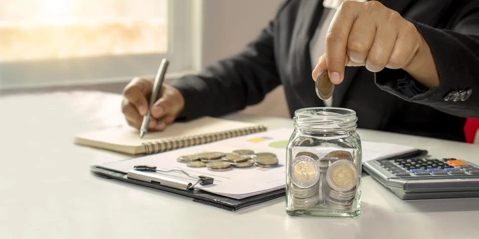 Working men aged 25-60, put coins in a glass jar to save money. Retirement .. Stock Photos
