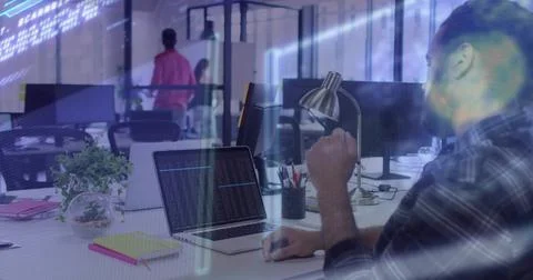 Working mid adult developer typing code on laptop at open-plan office in checked Foto stock