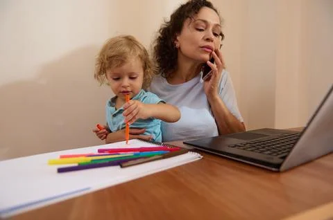 Working Mother Balancing Remote Work While Caring for Child at Home Stock Photos