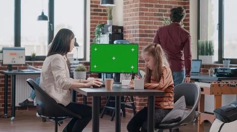 Working mother using horizontal green screen on computer and little girl Stock Photos