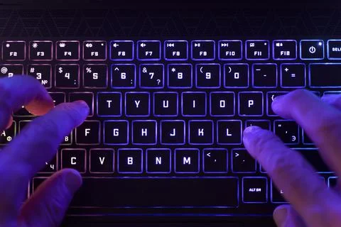 Working on a neon computer keyboard with colored backlighting. Computer video Foto stock