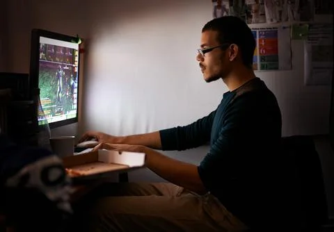 Working on a new game. a young programmer focused on his work. Stock Photos