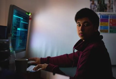 Working on a new game. a young programmer focused on his work. Stock Photos