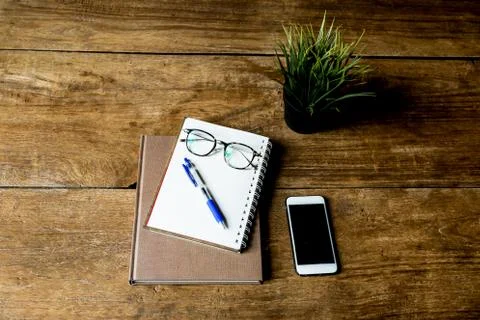 Working object notebook and pen with glasses and cell phone on wooden table. Stock Photos