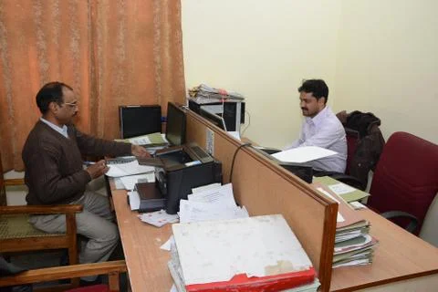 Working at a office to do the critical work while maintaining social distancing. Stock Photos