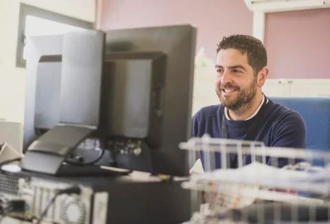 Working office worker smiling at pc Stock Photos