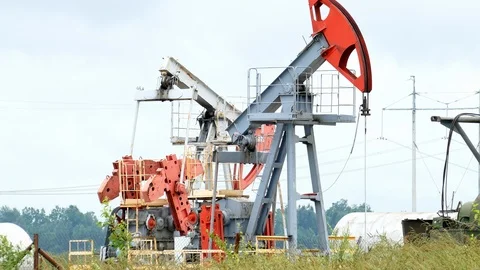 Working Oil Pump Jack in a Rapeseed Field Stock-Footage 95890477