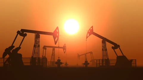 Working oil pump jacks in a desert against sunset extracting crude oil Stock Footage 126930833