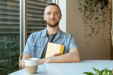 Working on an online course while seated at a table with a cup of coffee an.. Фото